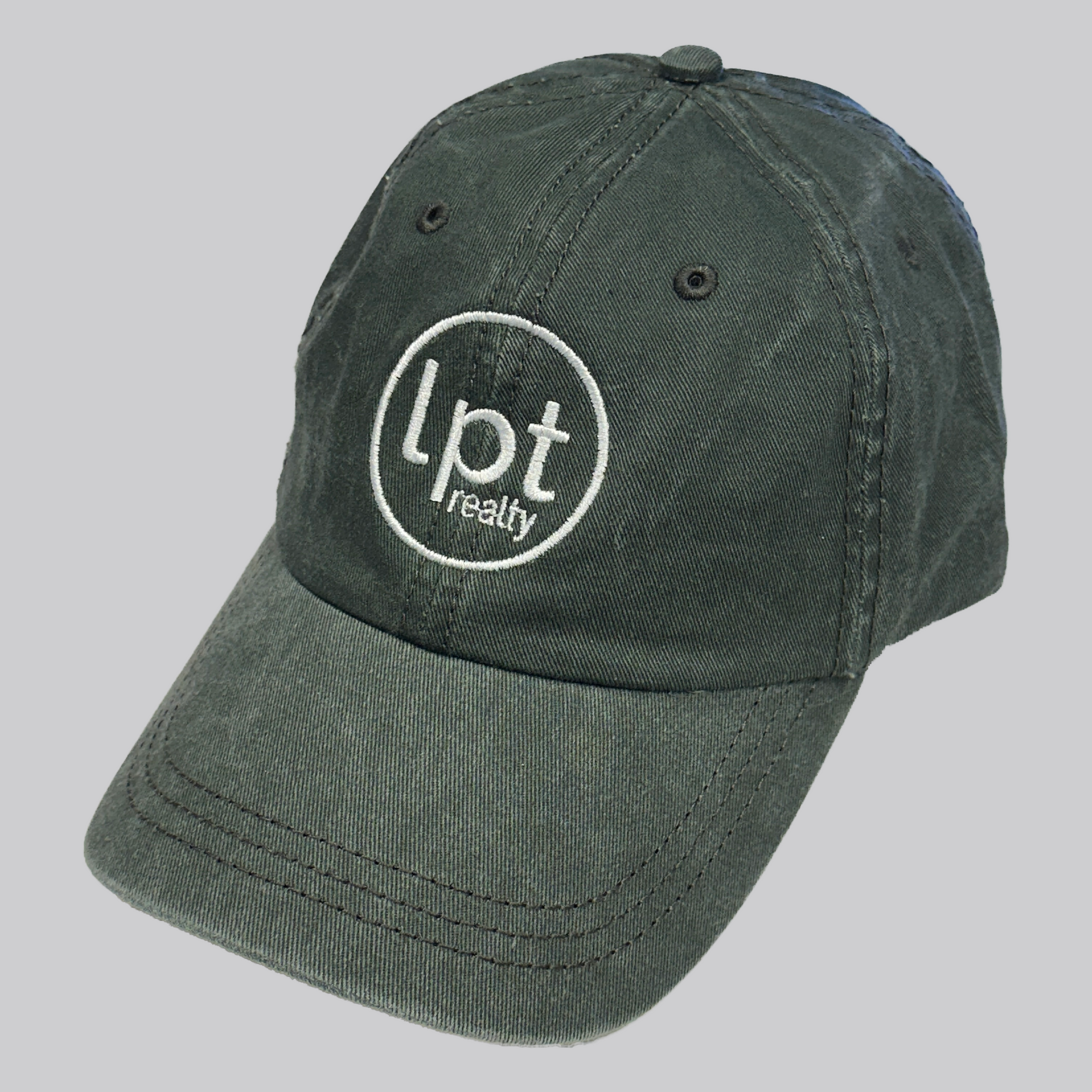 A casual, washed denim cap in olive green with the “lpt realty” circle logo embroidered in white across the front panels. Stitching and embroidered eyelets are in matching green thread. 