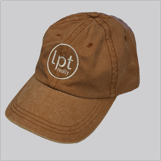 A casual, washed denim cap in a muted orange with the “lpt realty” circle logo embroidered in white across the front panels. Stitching and embroidered eyelets are in matching orange thread. 