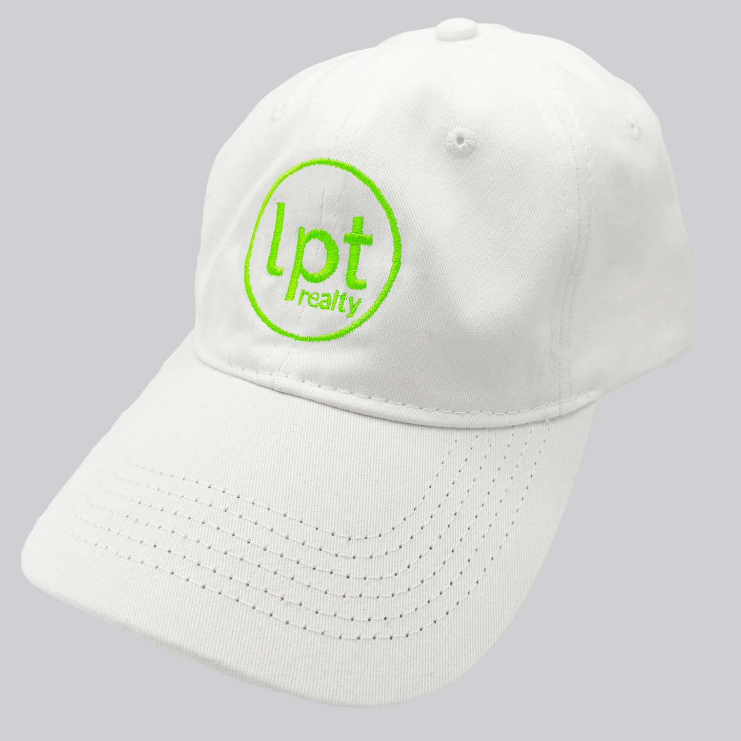 A white twill cap with a relaxed fit, matching stitching, and embroidered eyelets. The front panels feature the “lpt realty” circle logo embroidered in vivid neon green. 