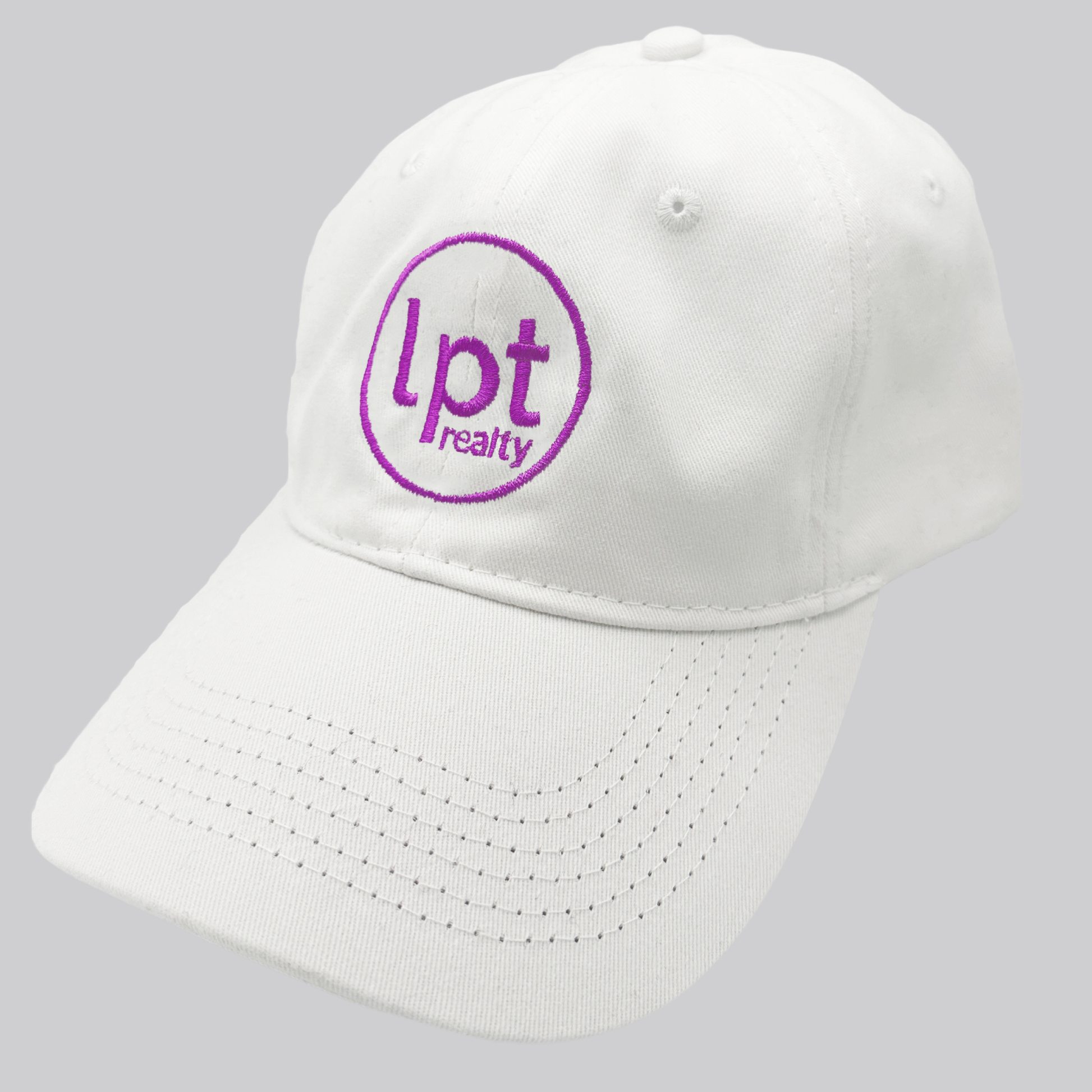 A white twill cap with a relaxed fit, matching stitching, and embroidered eyelets. The front panels feature the “lpt realty” circle logo embroidered in vivid purple. 