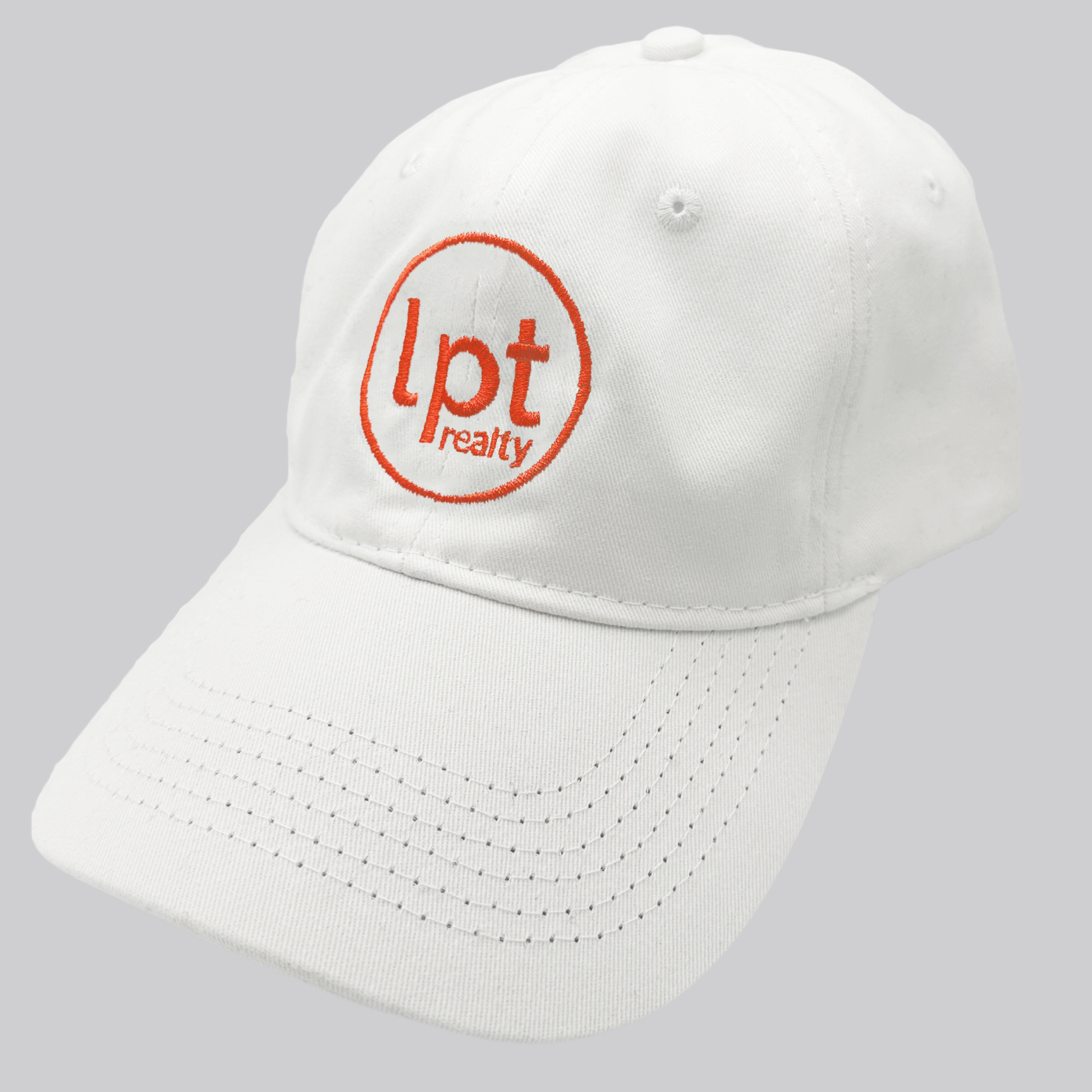 A white twill cap with a relaxed fit, matching stitching, and embroidered eyelets. The front panels feature the “lpt realty” circle logo embroidered in red. 