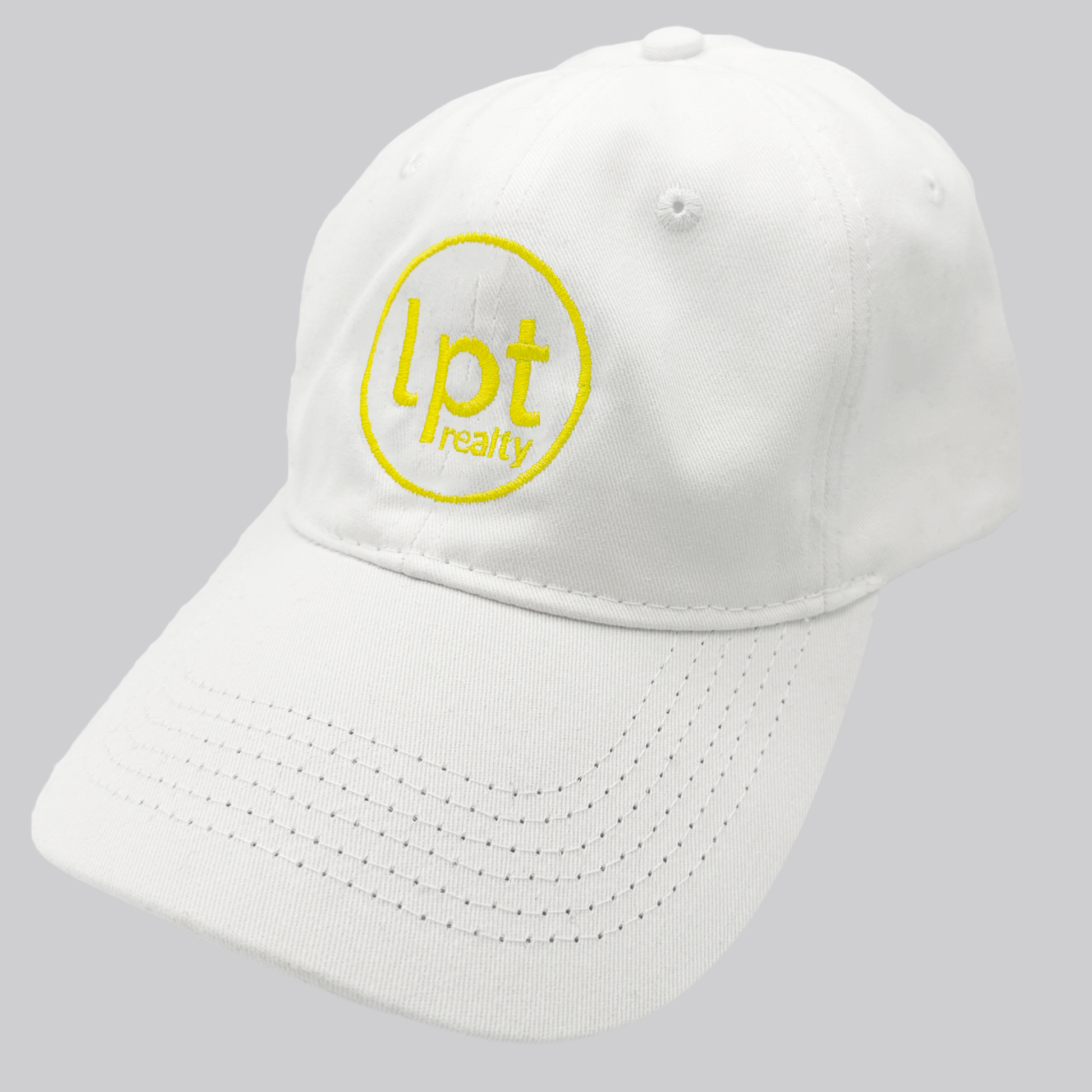 A white twill cap with a relaxed fit, matching stitching, and embroidered eyelets. The front panels feature the “lpt realty” circle logo embroidered in bright yellow. 