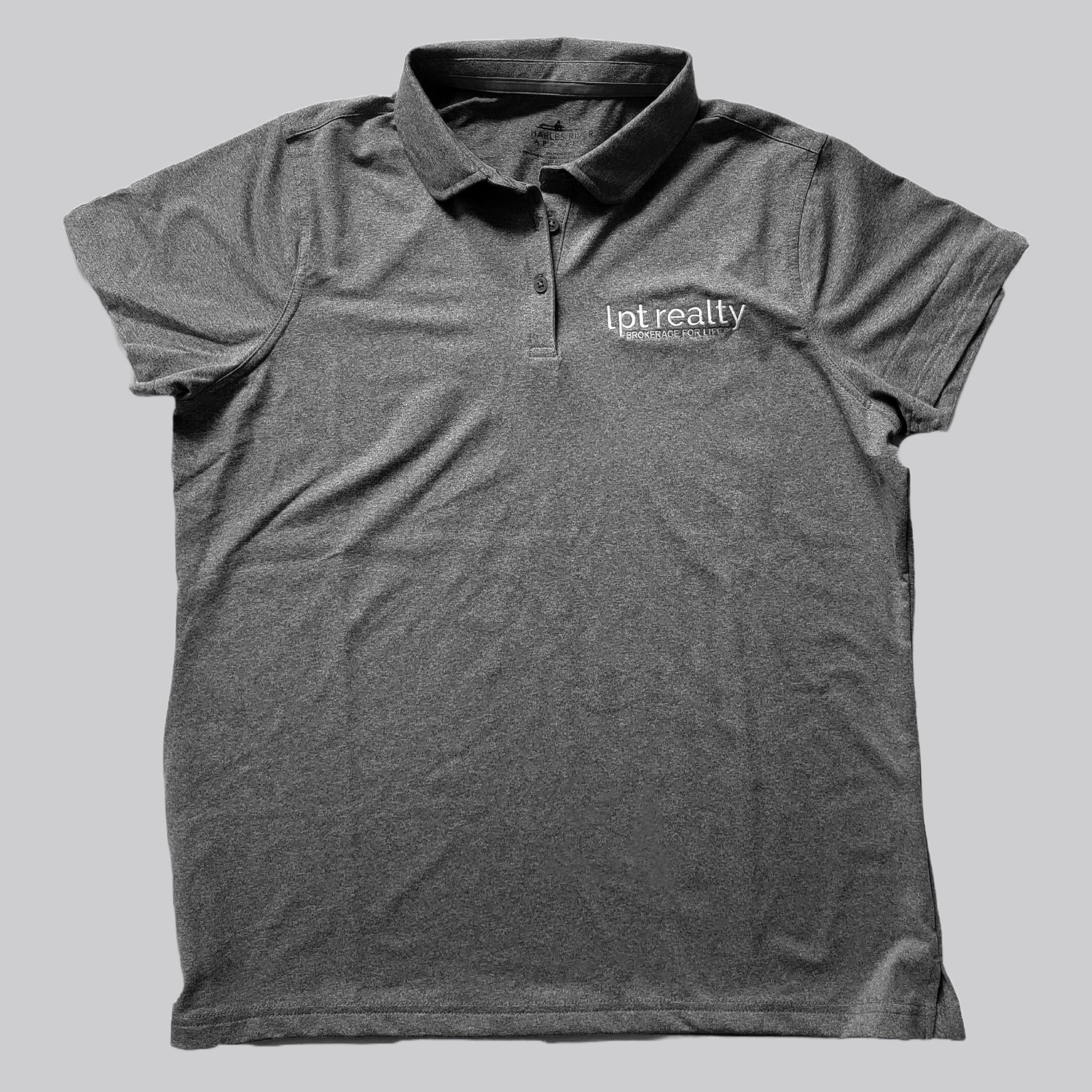 A heathered dark gray polo shirt with a subtle sheen from the stretch fabric. The upper left chest features “lpt realty” in white, embroidered lowercase letters, with “BROKERAGE FOR LIFE” in smaller, all caps beneath it. The shirt’s placket has 3 buttons in matching gray, the collar is the same fabric as the shirt, and the sleeves are open with no cuffs. 