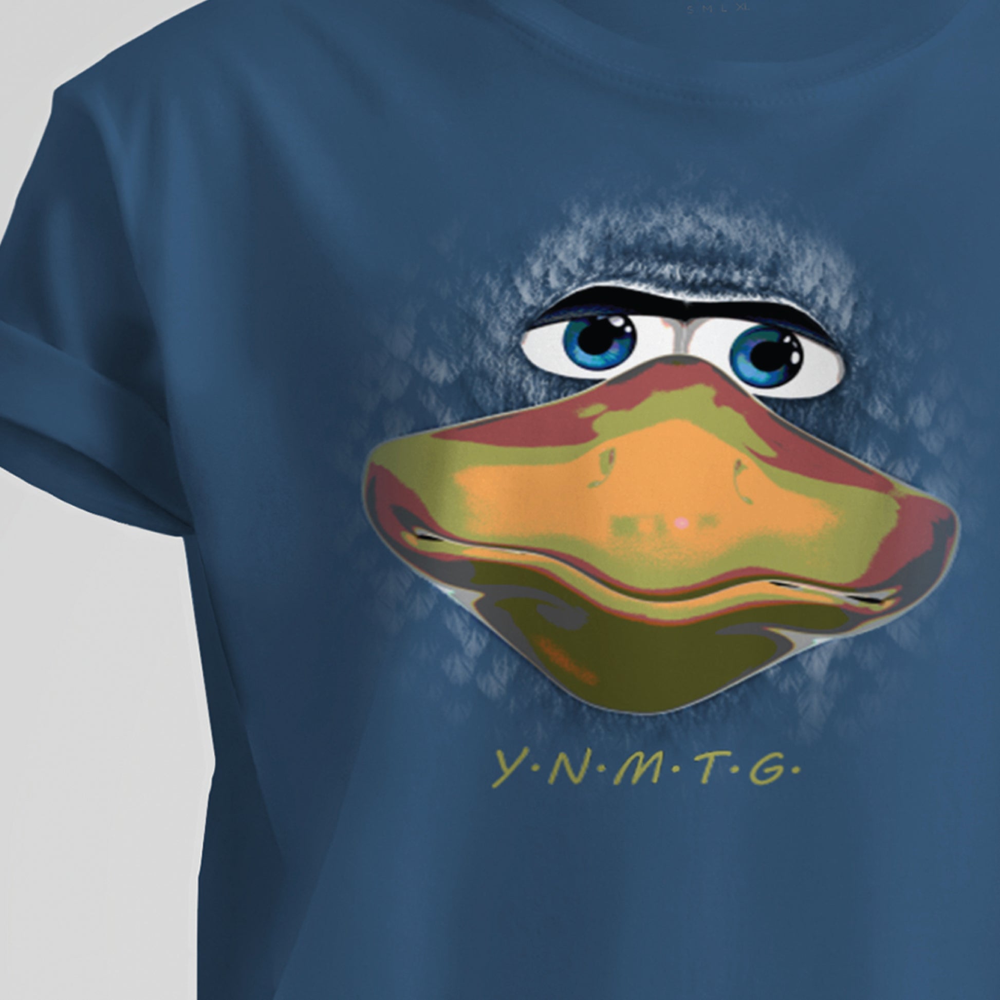 A steel blue t-shirt featuring a close-up image of mascot Larry Bird’s face, designed with a hand-painted appearance. A large beak and vivid blue eyes are surrounded by small, faded feather impressions. Beneath the image, separated by small dots, are gold letters spelling “YNMTG”.  